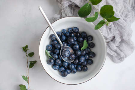 Plate with fresh blueberries on a light backgroundの写真素材
