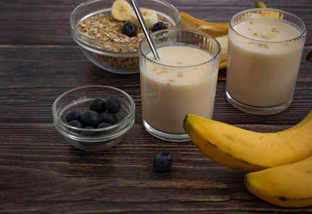 Banana, oatmeal, milk on a wooden background