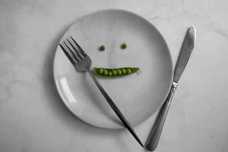 Green peas on an empty plateの写真素材