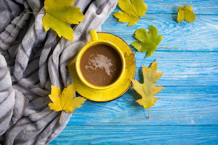 Cup of coffee, autumn leaves on old background, sweater