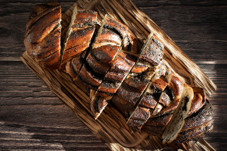 Appetizing bun with poppy seeds on an old background