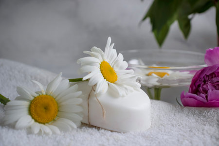 Cosmetic soap, chamomile flower, peony on a light backgroundの写真素材