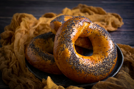 Bagel with poppy seeds on wooden backgroundの写真素材