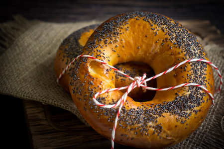 Bagel with poppy seeds on wooden backgroundの写真素材