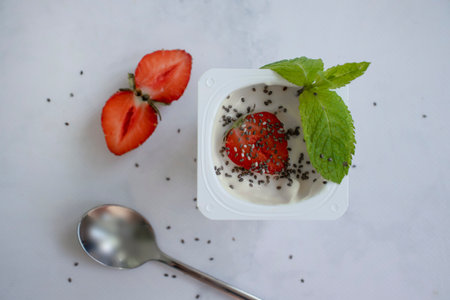 Yogurt chia seeds, strawberries, mint on a light backgroundの写真素材