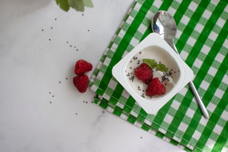 Yogurt chia seeds, raspberries, mint on a light backgroundの写真素材