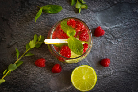 Cold water with mint, raspberry, lime on old backgroundの写真素材