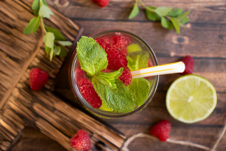 Cold water with mint, raspberry, lime on old background