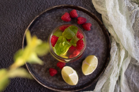 Cold water with mint, raspberry, lime on old background