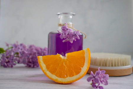 Massage brush, cream, lilac flower, orange on a light backgroundの写真素材