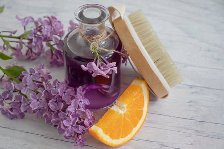 Massage brush, cream, lilac flower, orange on a light backgroundの写真素材