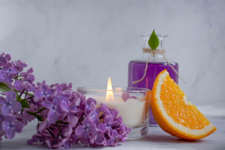 Perfume for home, lilac flower, candle on a light backgroundの写真素材