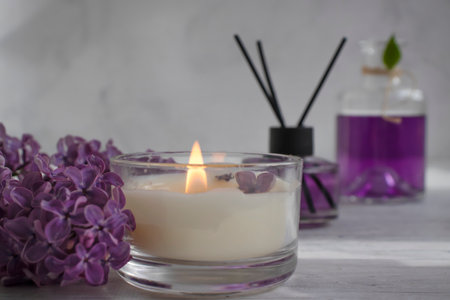 Perfume for home, lilac flower, candle on a light background