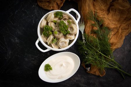 Dumplings with sour cream and herbs on an old backgroundの写真素材