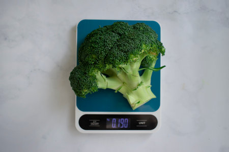 Fresh broccoli kitchen scale on a light backgroundの写真素材