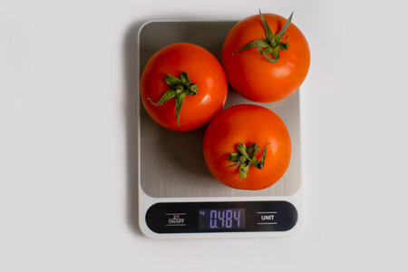 Electronic kitchen scales, tomato on a light backgroundの写真素材