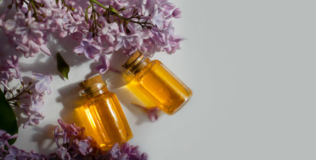 Cosmetic oil, lilac flower on a light backgroundの写真素材
