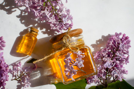 Cosmetic oil, lilac flower on a light backgroundの写真素材