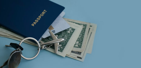 Passport, dollar airplane keychain on a colored backgroundの写真素材