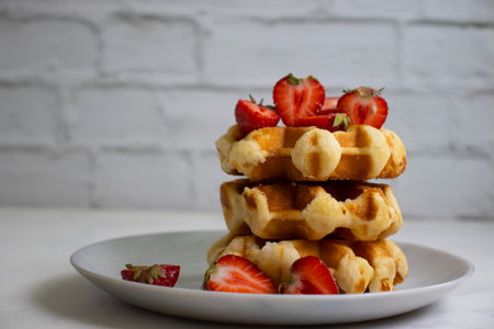 Waffles with strawberries on a light backgroundの写真素材