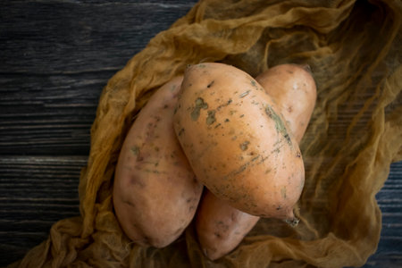 Raw sweet potato on old backgroundの写真素材