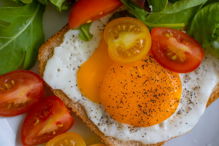 Bread with fried egg, tomatoes, lettuce