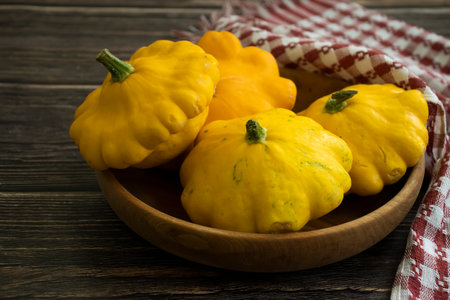 Fresh yellow pattypan squash on wooden background. Selective focus. Toned.