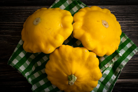 Fresh yellow pattypan squash on wooden background. Selective focus. Toned.の写真素材