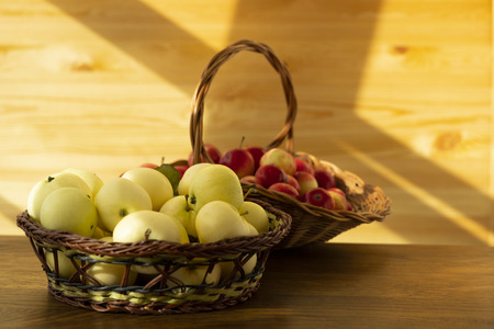 Red and yellow apples in a buskets on a wooden tableの写真素材
