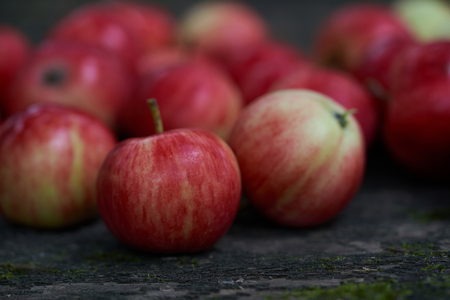 Red apples on an old black wooden surfaceの写真素材