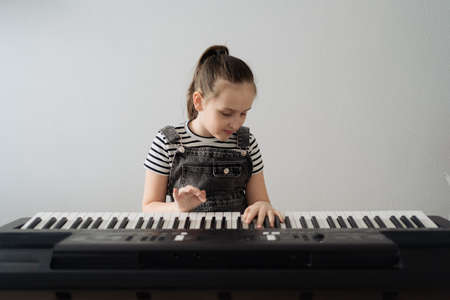 Child playing piano. Kids play music. Classical education for children. Art lesson. Little girl at...