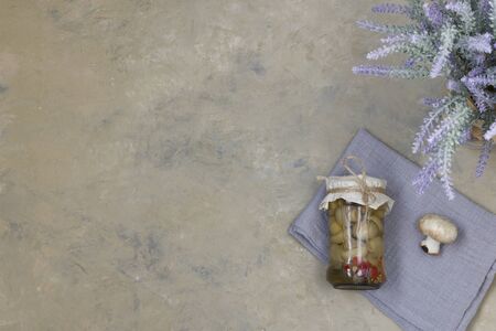 Fermented champignons in a glass jar on a light background with garlic on a cotton napkin. Horizontal position. Copy space. View from above.の写真素材