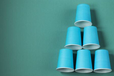 Paper cups on a mint background. Ecological tableware. Minimalistic style. Top view. Copy space.の写真素材