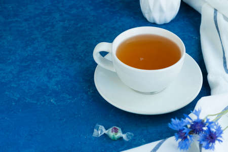 Herbal chamomile tea with fresh chamomile flowers in a transparent glass cup on a light background. Horizontal position Copy space.の写真素材