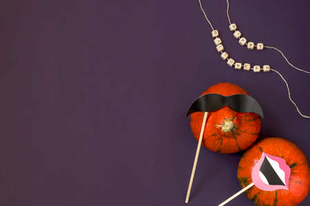 Text Happy Halloween in wooden letters, pumpkin man and pumpkin woman on a dark background, paper mustaches and lips, flat lay. Atmospheric image. Autumn postcard. Copy spaceの写真素材
