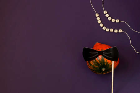 Text Happy Halloween in wooden letters, pumpkin on a dark background, paper bow tie, flat lay. Atmospheric image. Autumn postcard. Copy spaceの写真素材