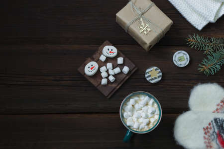 Christmas New Year card. Cup of hot drink with marshmallows, warm white mittens, New Year's gift,...