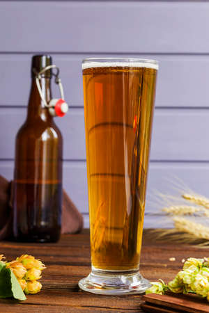 Home brewing concept. Still life with hops, beer and barley on a wooden background. Close-up. Make a lager beer with natural ingredientsの写真素材