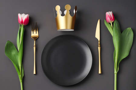 Festive creative royal table setting with a bouquet of tulips on a dark background. Gold crown, fork...