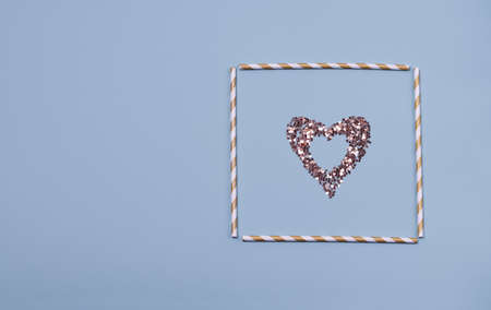 Heart shaped frame made of shiny sequins on a blue background. Festive texture for Valentines Day, Mothers Day, Womens Day, day of the wedding and Birthday. Flatlay, copy spaceの写真素材