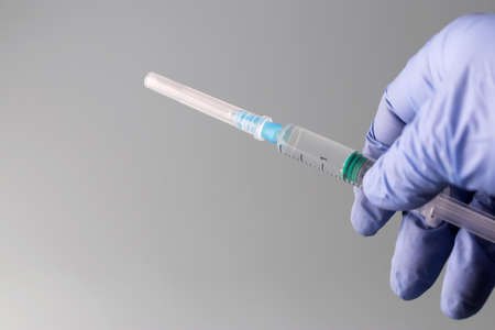 hands are holding a syringe filled with vaccine. Prevention, immunization and treatment for coronavirus infection COVID-19, nCoV 2019. COVID19 vaccine concept. Copy space.の写真素材