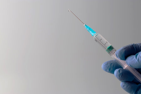 Doctor's hands are holding a syringe filled with vaccine. Prevention, immunization and treatment for coronavirus infection COVID-19, nCoV 2019. COVID19 vaccine concept. Copy space.の写真素材