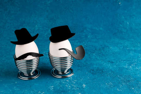 White eggs of a chicken farm on a turquoise background. Gentlemen at breakfast. Easter creative holiday concept. Copy spaceの写真素材