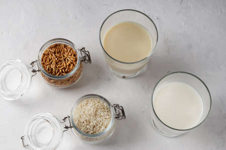 Vegetable vegan milk in mugs on a wooden background. Gluten and lactose free healthy food concept. Diet drinks for breakfast. Country style. Top viewの写真素材