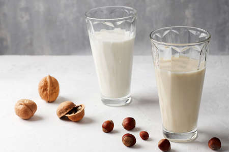 Vegetable vegan milk in mugs on a wooden background. Gluten and lactose free healthy food concept....