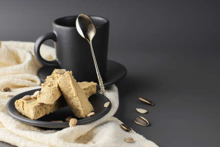Halva with pistachios on parchment paper on a wooden background. Natural vegan product. Turkish, Arab and Jewish national sweets. Traditional oriental dessert Chekmeの写真素材