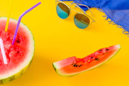 Watermelon, blue sunglasses and pareo on a yellow background. Summer vacation conceptの写真素材