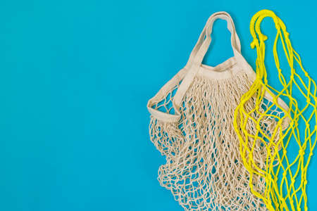 Zero waste concept. Empty reusable eco shopping bags on a blue background for shopping. Flat lay. Copy space.の写真素材