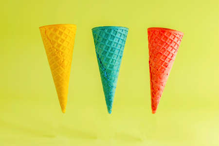 Colored waffle cones for ice cream on a light background. Summer creative concept. Levitation.の写真素材