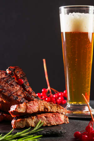 Meat cut on a stone board with rosemary and berries. Vertical position. Copy spaceの写真素材